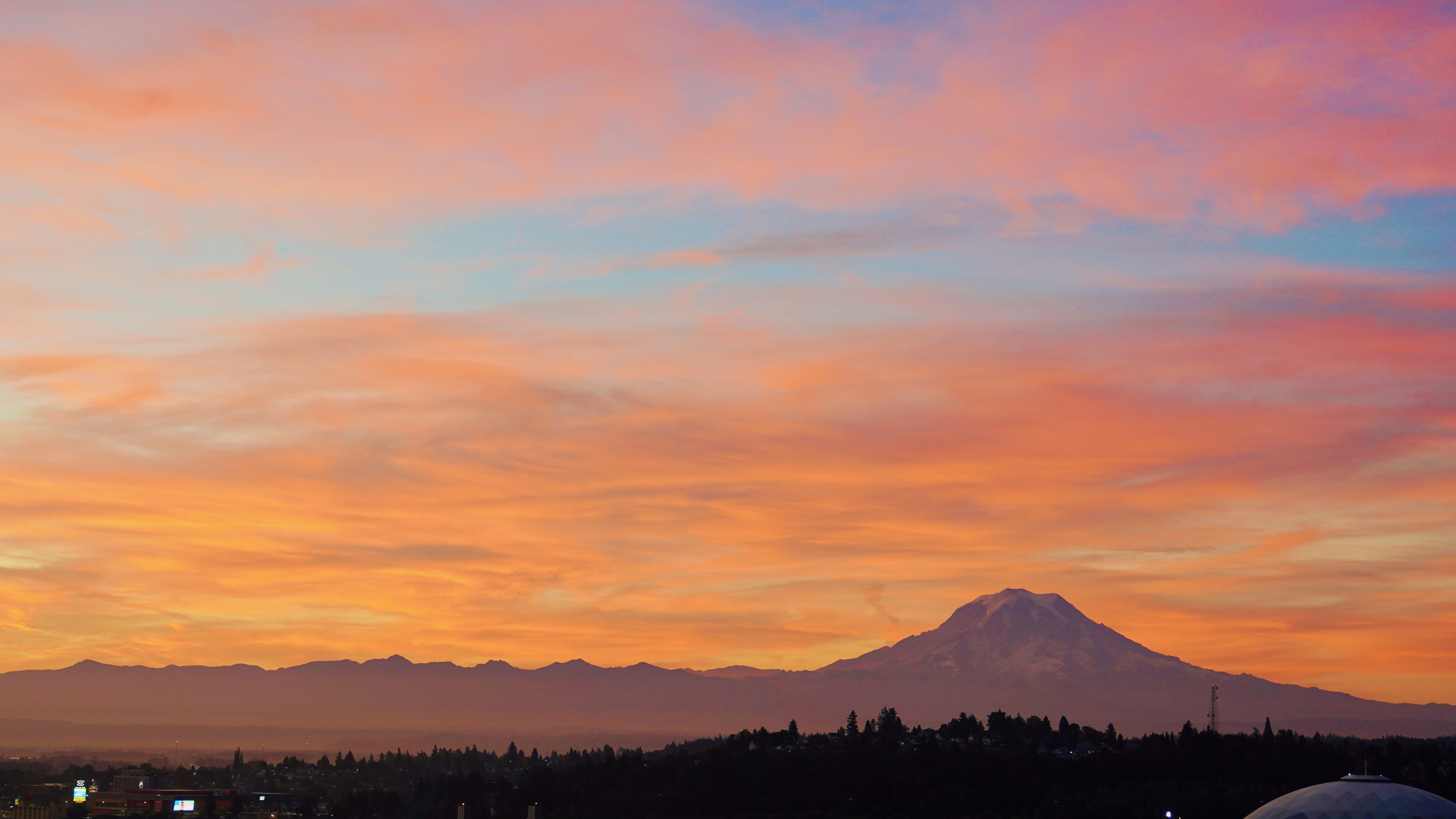 Mt. Rainier at sunrise with fiery orange and pink sky
